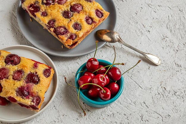 Clafoutis kersentaart traditionele Franse taart in borden op de grijze tafel met kopieerruimte