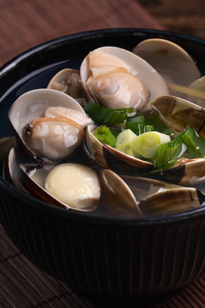 Clam soup Close up of delicious food in a bowl on wooden table