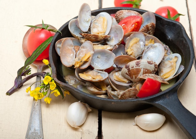 Photo clams in cooking pan on table