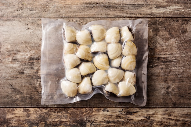 Clams packaged in plastic on wooden table