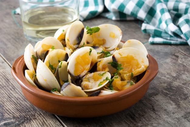 Clams with marinera sauce.Almejas a la marinera. Spanish recipe on wooden table