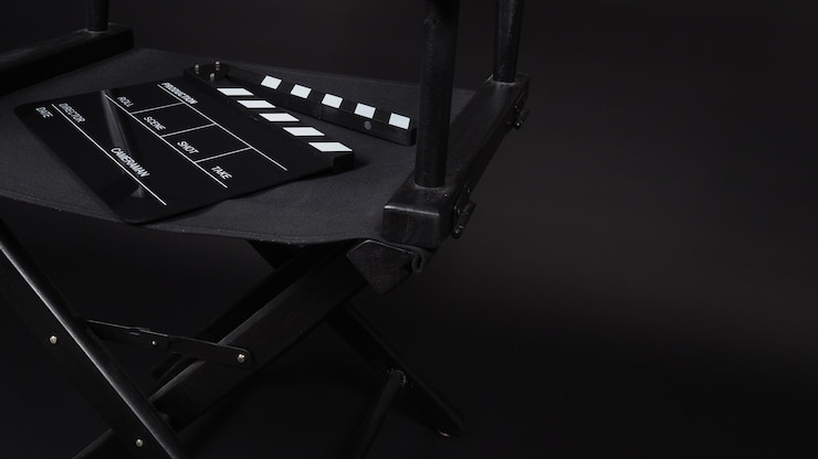 Photo clapper board or movie slate with director chair use in film production in black background