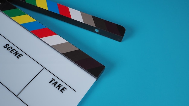 Photo clapperboard or movie slate on blue background.