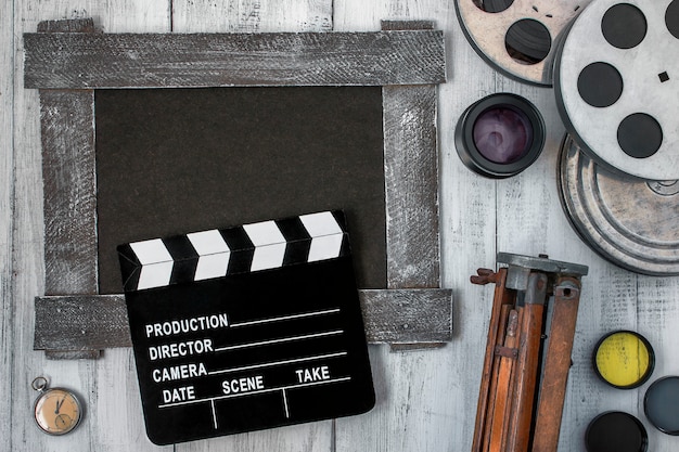 Clapperboard, reels of film and a tripod