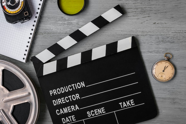 Photo clapperboard, a roll of film, and the clock on the table