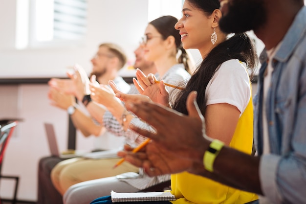 Battere le mani. studenti entusiasti allegri che applaudono e guardano il loro insegnante dopo aver superato l'esame finale