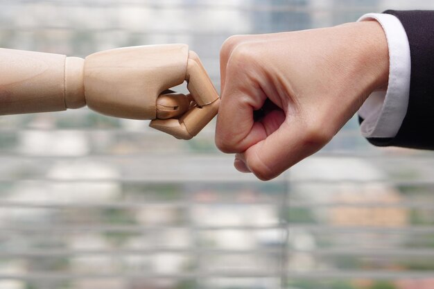 Clash of fists between businessman hand and robot hands concept\
of artificial intelligence progress