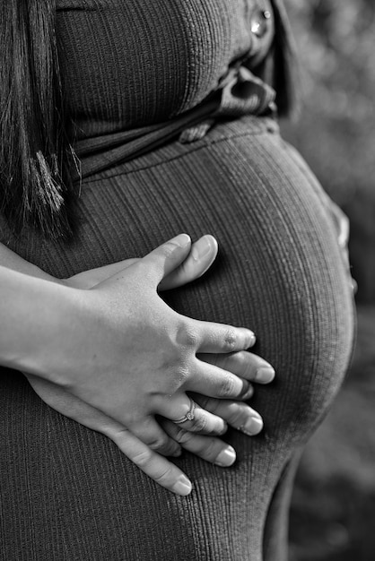 Clasped hands on the belly of a pregnant woman