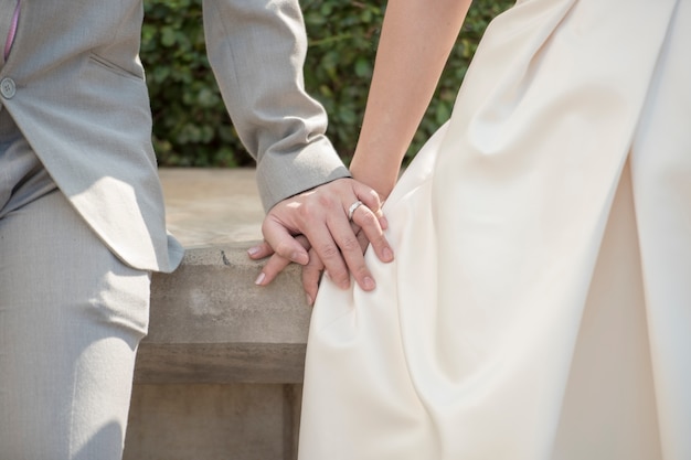 Clasped hands of the bride and groom with rings