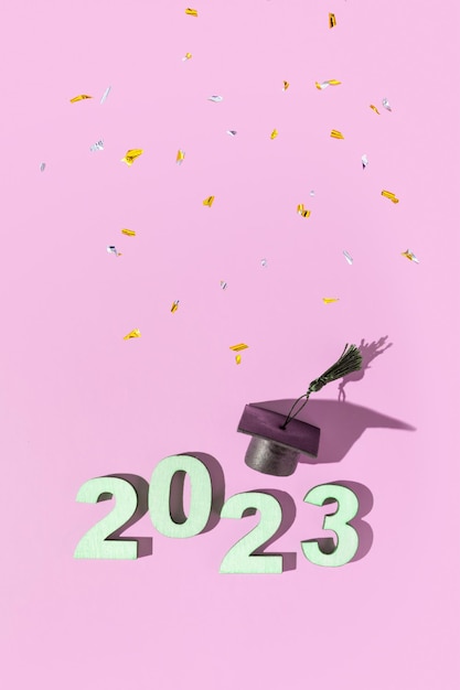 2023 年のクラスのコンセプト番号 2023 色付きの背景に黒の卒業キャップ