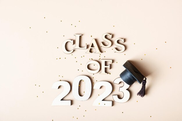 Photo class of 2023 concept wooden number 2023 with graduated cap on colored background