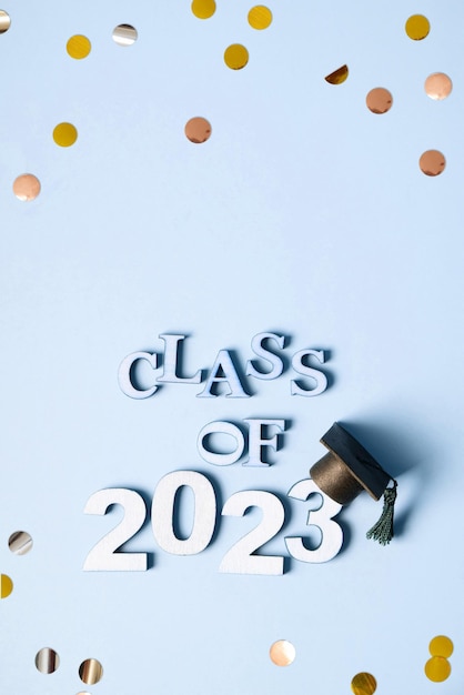 Фото Концепция класса 2023 года деревянный номер 2023 с градуированной крышкой на синем фоне с видом сверху на мишуру