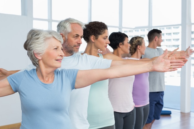 Class stretching hands in row at yoga class