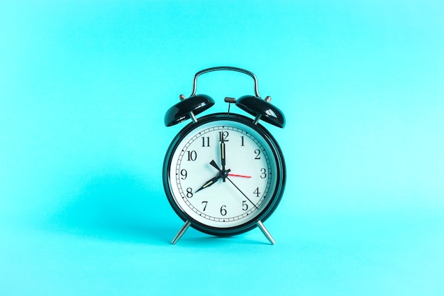 Classic alarm clock indicates 8 oclock isolated blue background