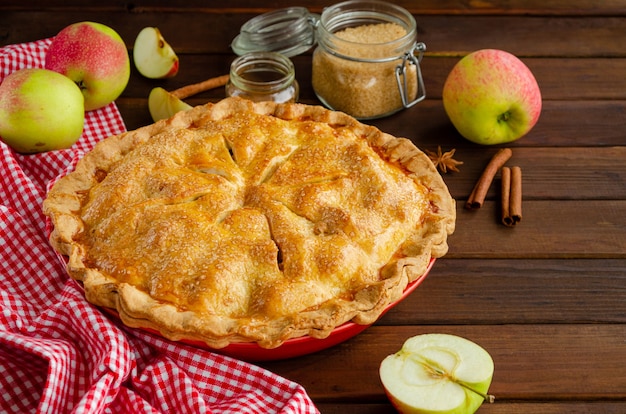 Foto torta di mele americana classica con cannella su uno sfondo di legno scuro.