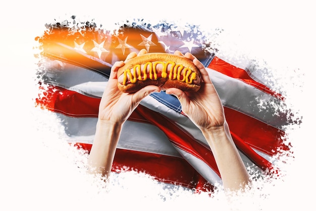 アメリカの国旗の背景に手に古典的なアメリカのホットドッグ
