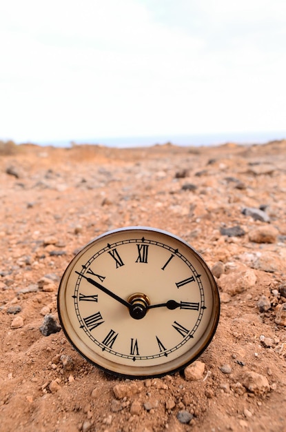 砂の中の古典的なアナログ時計