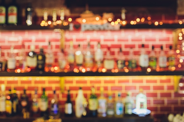 Classic bar counter with bottles in blurred background, copy space