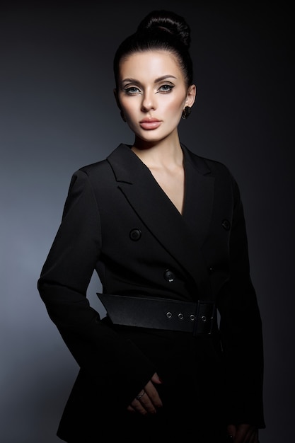 Photo classic beauty portrait of woman with perfect evening makeup on dark background. perfect skin without wrinkles, professional beauty makeup, long eyelashes. perfect girl in black clothes