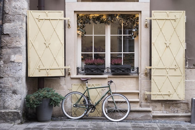 Classic bicycle standing near beautiful window on the street in europe