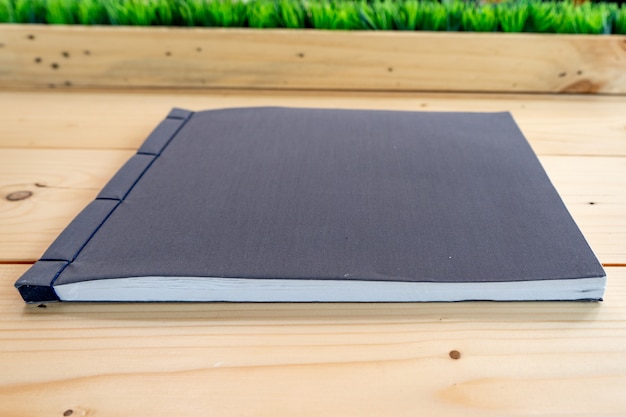 Classic black notebook on the wood table.