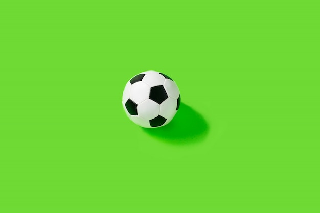 Classic black and white soccer ball on green wall.