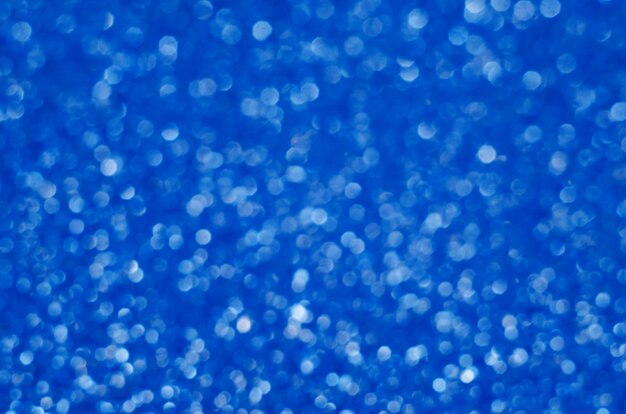 Colore blu classico. colore dell'anno 2020. bokeh festivo astratto con brillanti scintille di sfocatura. sfocato luccica luccicante macro polvere da vicino, copia spazio per logo testo