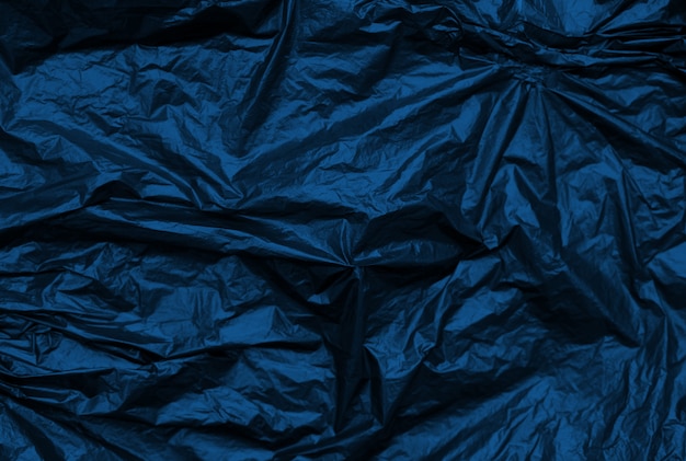 Classic blue crumpled metallic synthetic texture background.