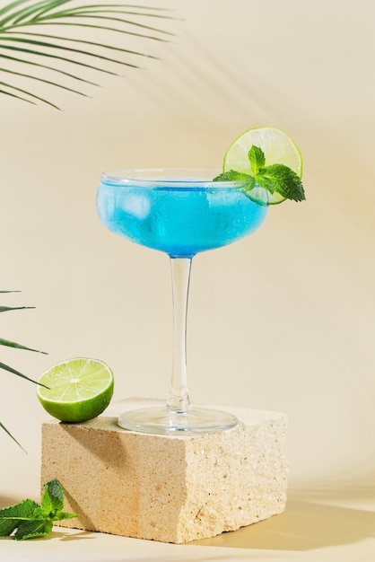 Classic  Blue Lagoon cocktail with lemon on modern still life on podium