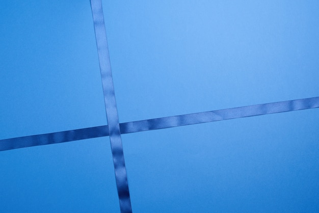 Classic blue silk ribbon crossed on a dark blue surface