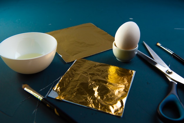 classic blue table with ingredients for gilding Easter eggs