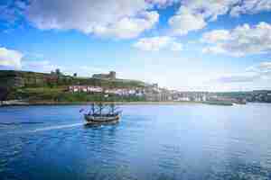 Photo classic boat on whitby harbour in whitby abbey