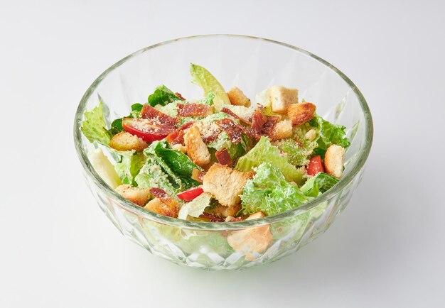 Классический салат Цезаря с беконом, смешанный с зеленым салатом, кротонами, хрустящим хлебом, хрупким беконом и помидорами.