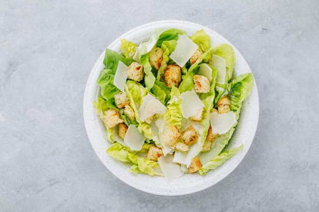 Insalata caesar classica con lattuga romana e condimento cremoso fatto in casa con parmigiano e crostini croccanti vista dall'alto spazio copia