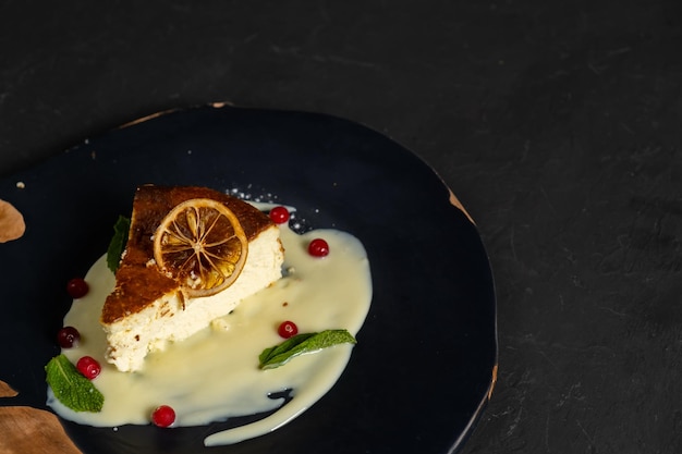 Classic cheesecake on a black background dessert on a black\
background in a black plate