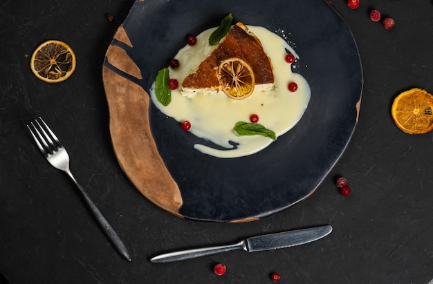 Classic cheesecake on a black background dessert on a black\
background in a black plate