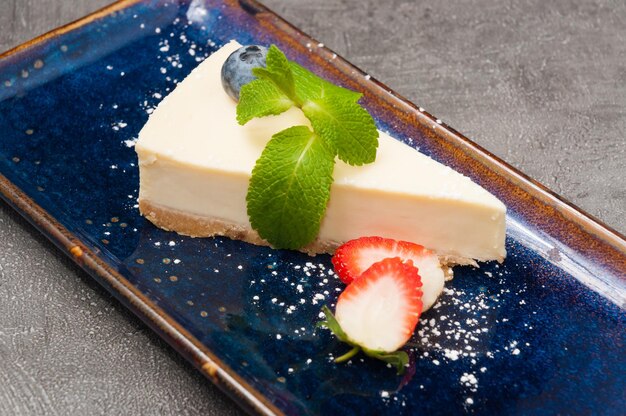 Classic cheesecake decorated with mint and strawberries