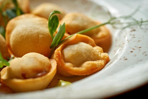 A classic Chinese dish - fried dumplings with meat and white sauce on a wooden background.