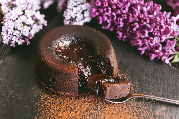 Classic chocolate fondant on a dark background with flowers