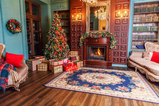 Photo classic christmas new year decorated interior room home library with fireplace christmas tree with red ornament decorations modern classical style interior design apartment christmas eve at home