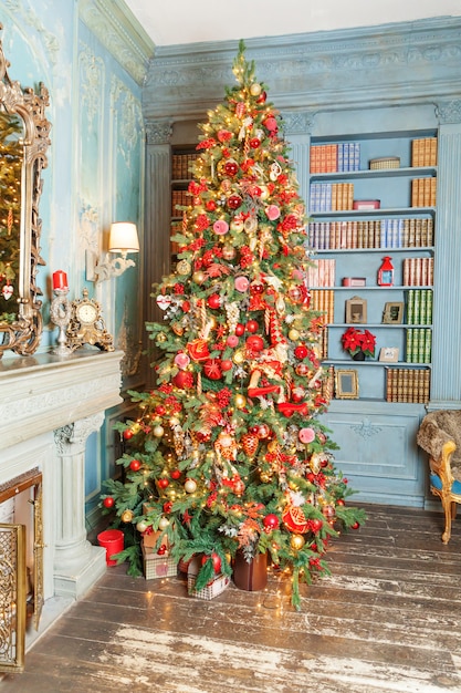 Классический новогодний интерьер украшен новогодней елкой с серебристым и красным орнаментом