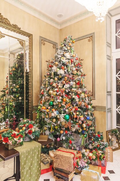 Classic Christmas decorated interior room, New year tree with red and gold  decorations. Modern white classical style interior design apartment with  fireplace and Christmas tree. Christmas eve at home. Stock Photo by ©