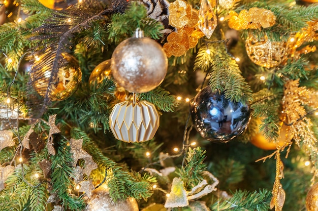 古典的なクリスマスの新年は、金色の飾りの装飾のおもちゃとボールで新年の木を飾りました。モダンな白いクラシックスタイルのインテリアデザインのアパート。自宅でのクリスマスイブ