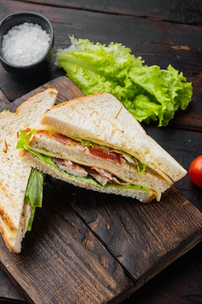 Classic club sandwich with meat, on dark wooden background