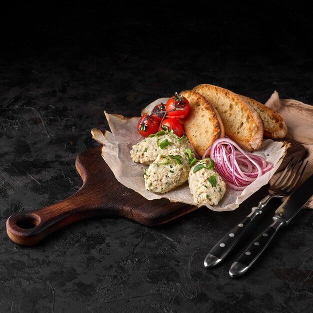 Classic dish of Israeli cuisine - herring forshmak with croutons served in a white plate on a marble background. Seafood.