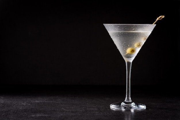 Classic Dry cocktail with olives on black background copy space