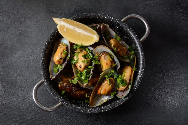 Classic French meal Moules mariniÃÂ¨re  Marinara mussels with garlic, sauce, lemon and parsley.