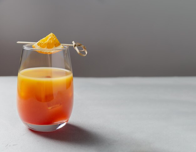 Photo classic garibaldi alcoholic cocktail with campari orange juice ice and slice of orange or mocktail