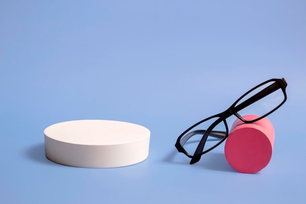 Classic glasses on a natural stone podium on a blue background Optics Close up with copy space