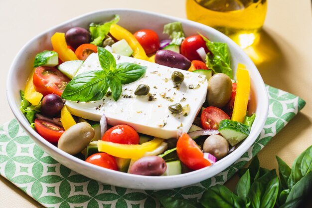 Classic Greek salad of fresh cucumber tomato sweet pepper lettuce red onion feta cheese and olives with olive oil